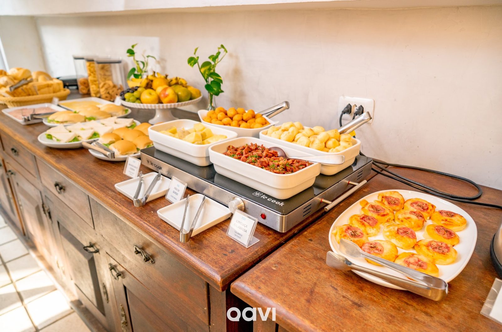 Buffet completo com pães, frutas e salgados quentes